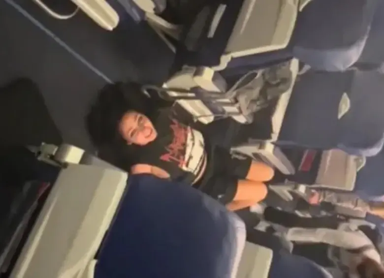 Momento en que Perry se arrojó al pasillo del avión y dijo que no podía respirar. FOTO: CAPTURA VIDEO REDES SOCIALES
