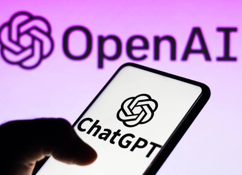 En primer plano, un celular con la aplicación de ChatGPT. Al fondo, la empresa OpenAI, los dueños de la IA mencionada. FOTO: DEPOSITPHOTOS