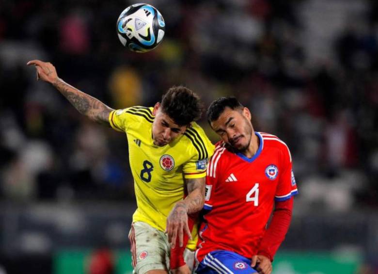 El volante ofensivo Jorge Carrascal disputando un balón aéreo contra un rival chileno. FOTO: AFP