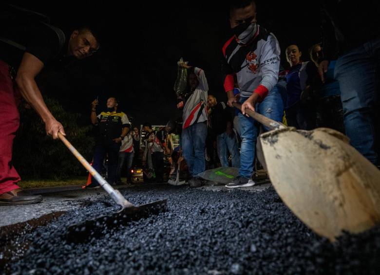 Los motorizados tapan los huecos de la Regional Sur, a la altura de Sabaneta, mediante máquinas y materiales gestionados por su cuenta. Alegan falta de respuesta institucional. FOTO camilo suárez