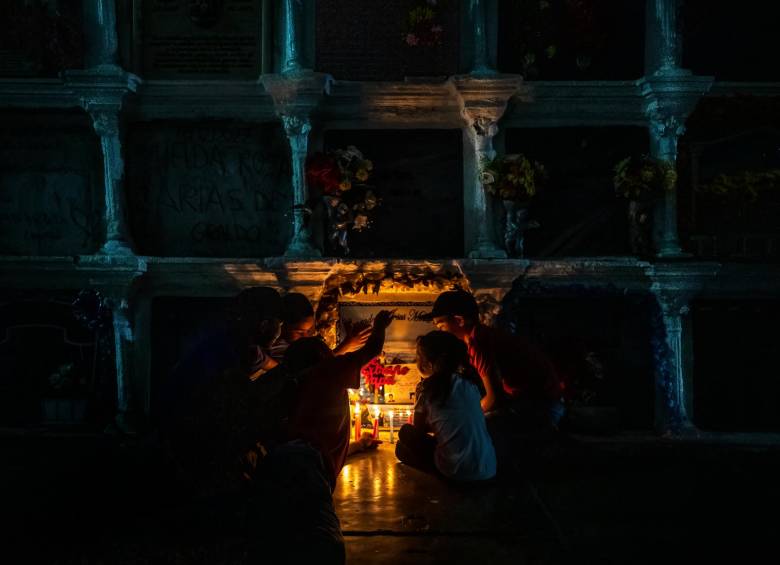 Esta es la primera Navidad que pasan sin Conrado de Jesús Mora Rojas. Sus nietos, alrededor de su tumba. FOTO CAMILO SUÁREZ