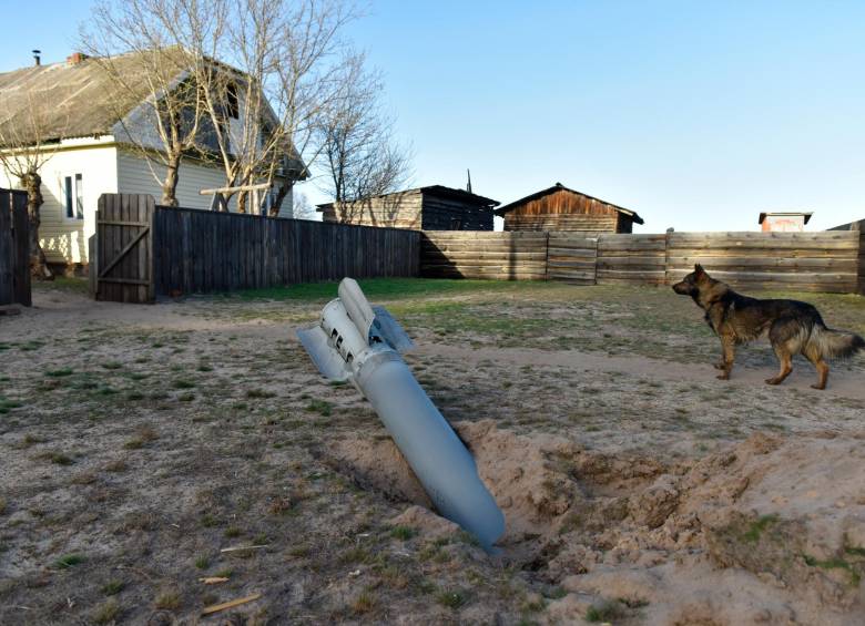 Un perro camina cerca de los restos de un misil en el norte de la región de Kiev. FOTO: EFE.