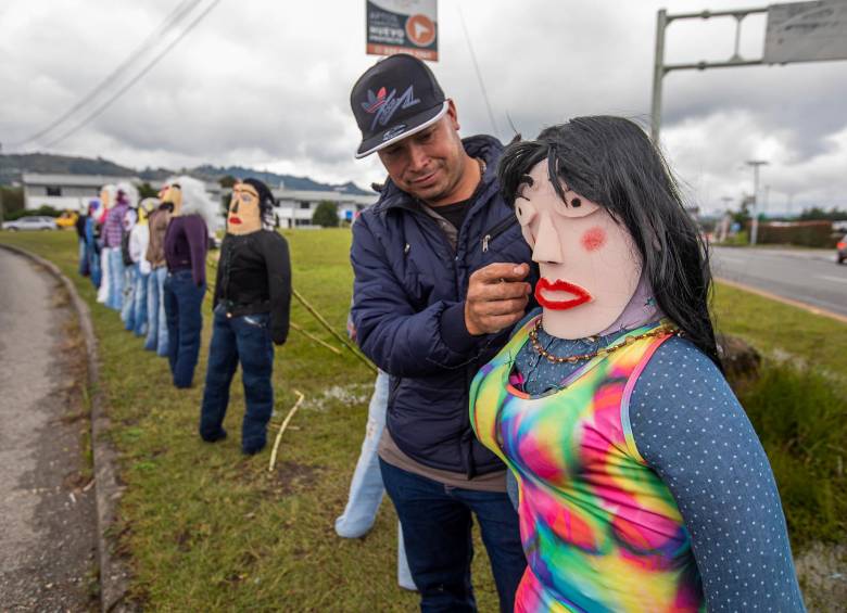 Uno de los vendedores de muñecos añoviejo en la glorieta del aeropuerto le da los últimos detalles a una de sus artesanías. FOTO: Camilo Suárez.