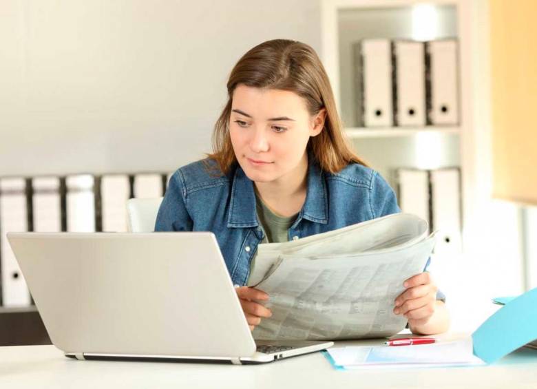 Persona joven buscvando un trabajo temporal en el periódico y en la web. FOTO: Getty