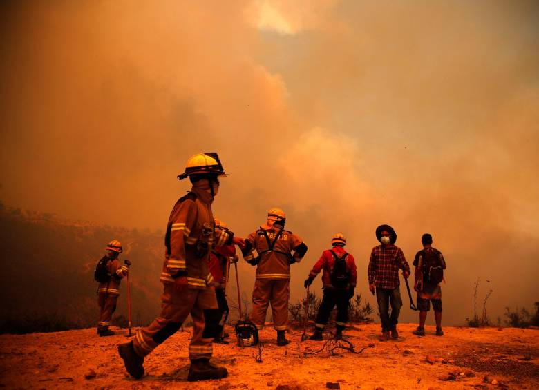 Los bomberos trabajan en la zona de un incendio forestal en las colinas de la comuna de Quilpe, región de Valparaíso. FOTO AFP