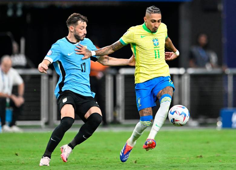 Raphinha, figura actual de Brasil, y Matías Viña, jugador uruguayo, en uno de los recientes duelos. FOTO GETTY