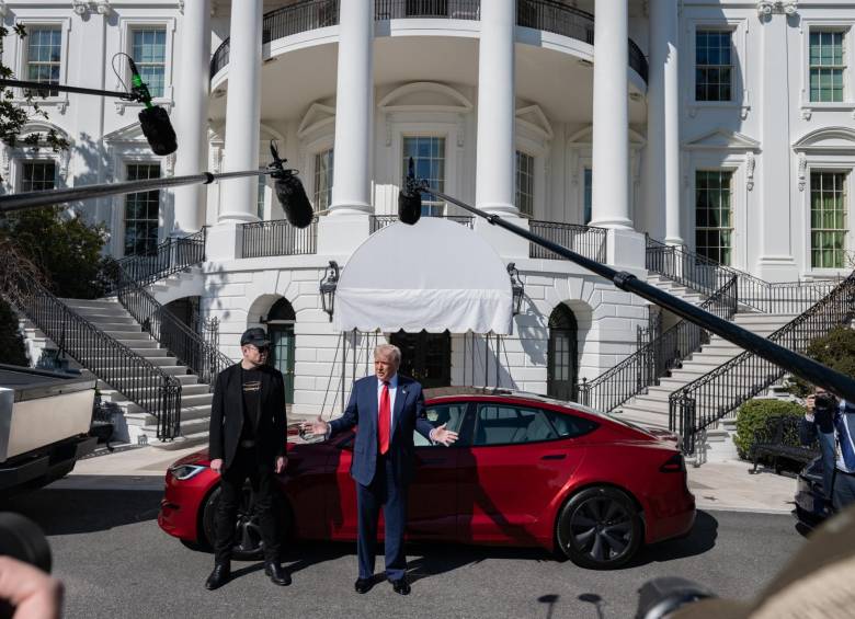 Trump junto a su carro Tesla, un sedán rojo brillante Modelo S y Elon Musk. FOTO: REDES SOCIALES CASA BLANCA