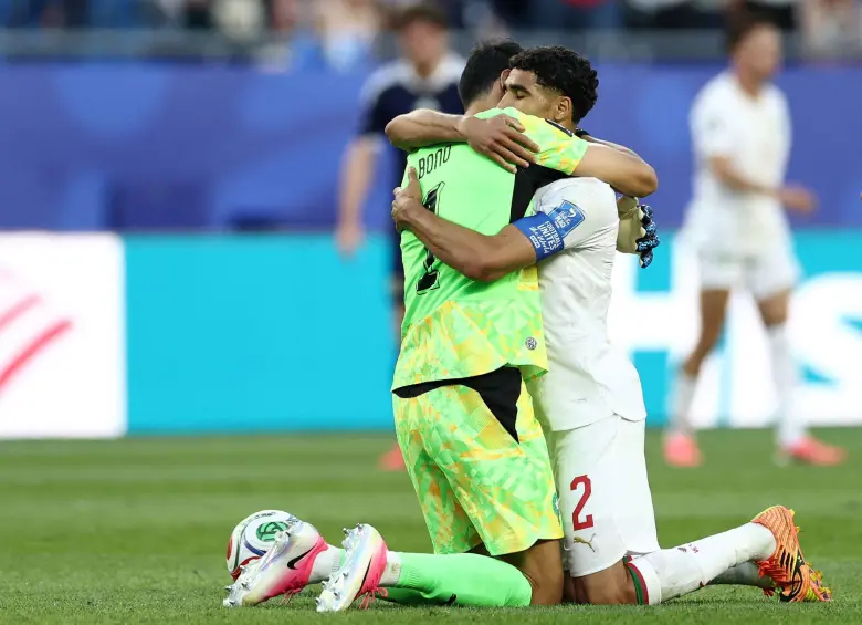 El arquero Bono y Hakimi se abrazan luego de conseguir la victoria ante Escocia. Foto: AFP