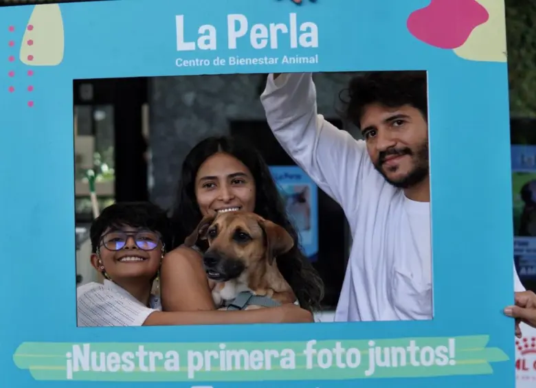 Una de las familias que decidió adoptar junto a su nueva mascota de La Perla. FOTO: Cortesía Alcaldía de Medellín.