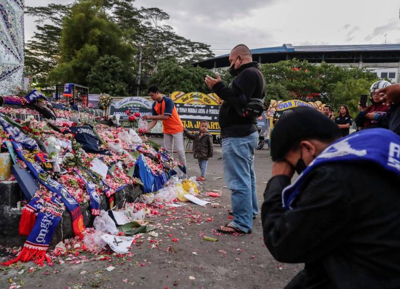 Cientos de personas llegan al estadio donde ocurrieron los hechos a expresar su dolor tras la tragedia. FOTO: EFE