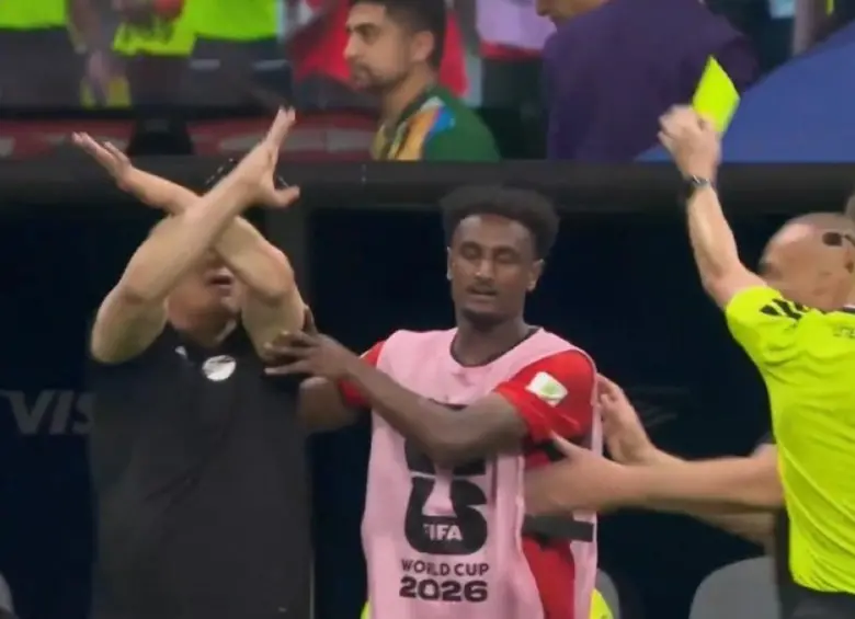 El entrenador de Egipto, Hossam Hassan, haciendo el gesto por presunto racismo, y el árbitro le sacó amarilla. FOTO: Captura de video de redes sociales @Dsports