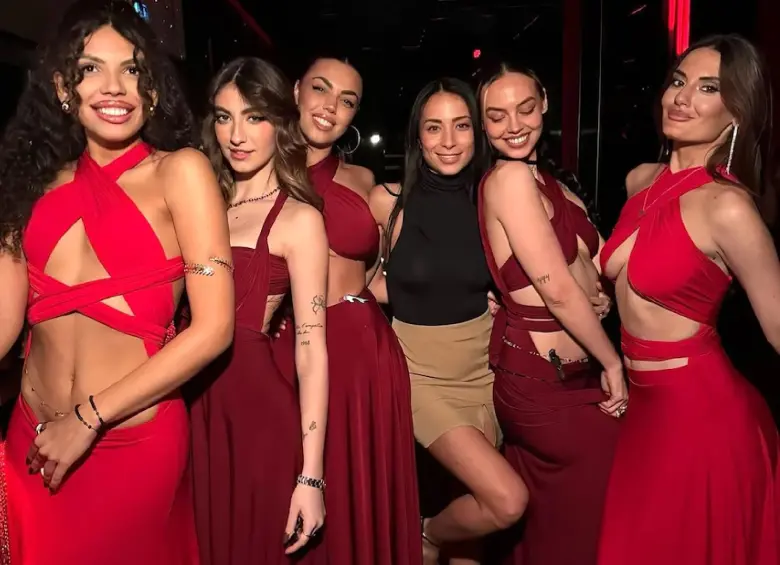 Un grupo de mujeres vestidas de rojo en medio de una fiesta relacionada con las investigaciones a la agencia. FOTO: Tomada de redes sociales de Emanuele Buttini