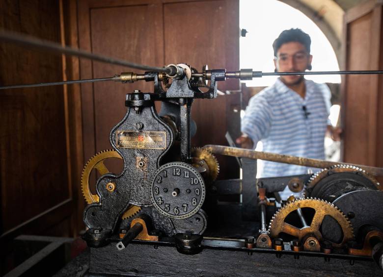 Ómar y el antiguo mecanismo del reloj de la iglesia, que fue contruido por los icónicos Talleres Robledo. Foto: Esneyder Gutiérrez