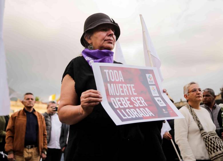 Una mujer sosteniendo una pancarta que dice “toda muerte debe ser llorada”. FOTO: COLPRENSA.
