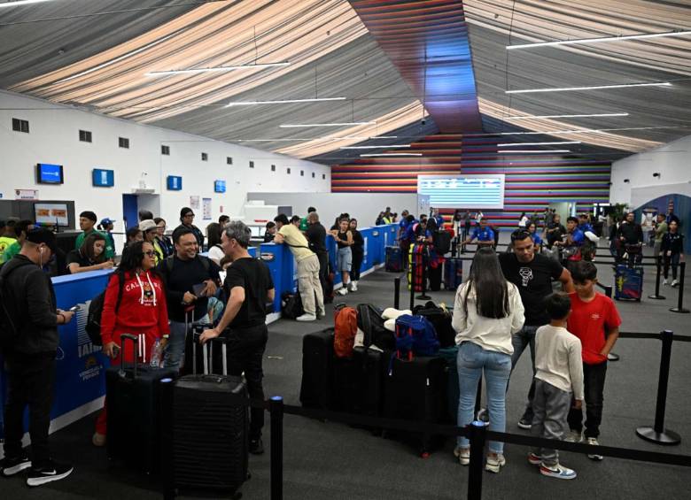 Los pasajeros se registran para sus vuelos en una de las carpas provisionales habilitadas para la reactivación de la operación comercial en el aeropuerto de Maiquetía-Simón Bolívar, que presta sus servicios a Caracas. Foto: AFP.
