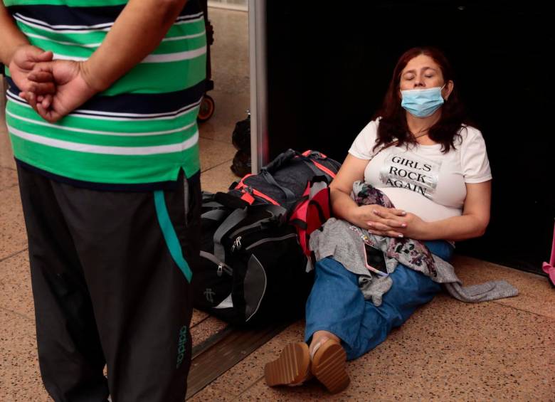 Vencida por la fatiga, una mujer se recuesta en el suelo del aeropuerto José María Córdova, en donde el caos ha reinado este martes. FOTO CARLOS VELÁSQUEZ
