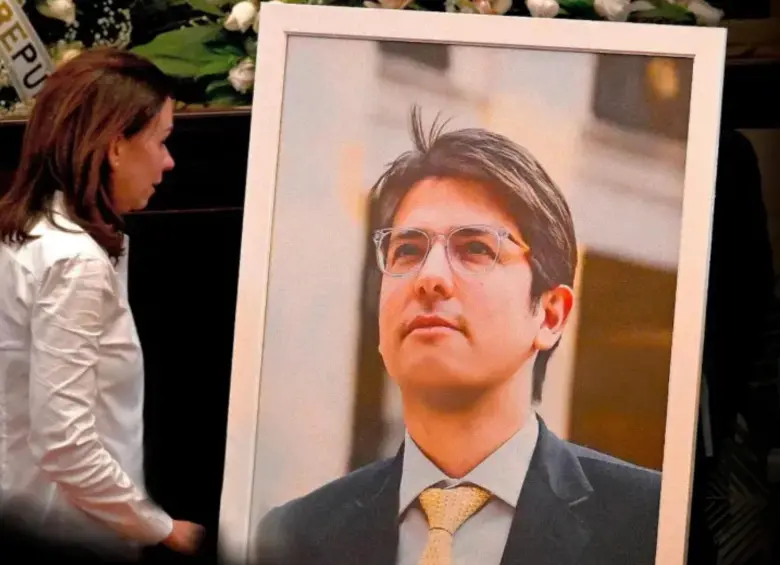 María Claudia Tarazona, durante el sepelio de Miguel en el Congreso de la República, mirando la foto de su esposo. FOTO: AFP