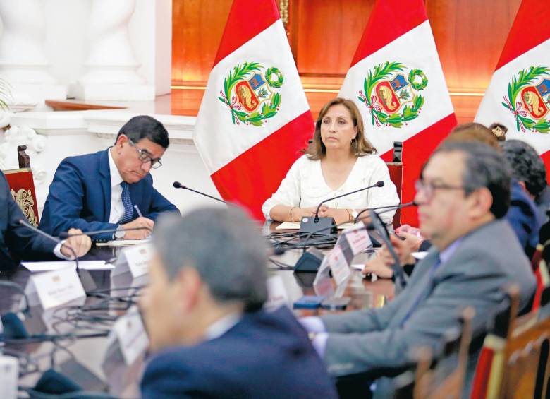 La presidenta del Perú, Dina Boluarte, lidero una reunión de su equipo para analizar salidas a la crisis que ya deja 28 muertos. Y en Ayacucho (al lado) familiares de una de las víctimas lo despiden. FOTOS Efe