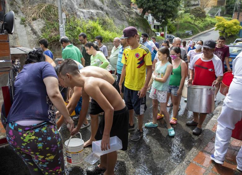 Gente haciendo fila por agua por corte del fluido de agua en un barrio de Medellín. Foto: EL COLOMBIANO