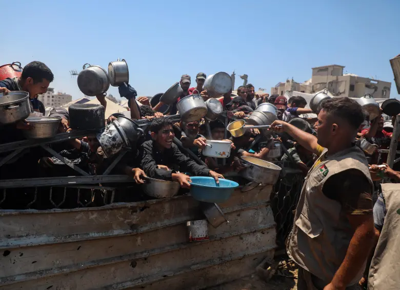 Un grupo de personas en Gaza espera con ollas y recipientes para recibir una ración de comida en medio de la grave escasez de alimentos denunciada por Médicos Sin Fronteras. Foto, Xinhua/Rizek Abdeljawad
