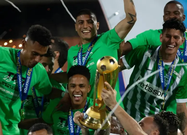 Juan Manuel Zapata (abajo) y el trofeo de la copa en medio de la celebración del equipo verde. FOTO: Camilo Suárez 