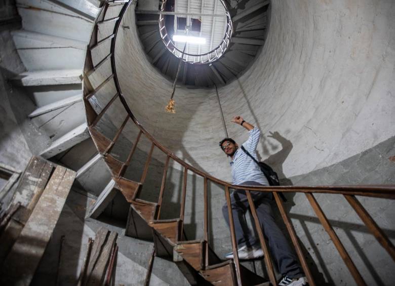 Ómar Portela, joven creador de contenido sobre la historia de Medellín, ascendiendo por la escalera de la torre del reloj de la iglesia de Boston. Foto: Esneyder Gutiérrez Cardona