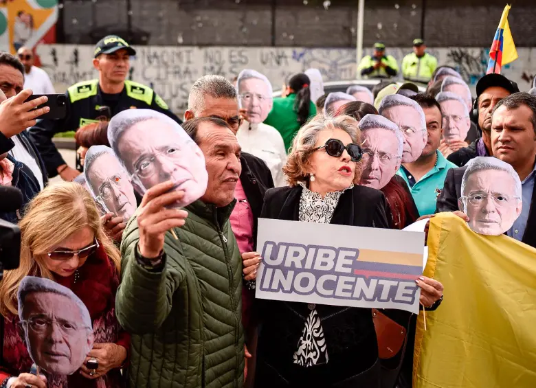 Simpatizantes de Álvaro Uribe a las afueras del complejo judicial de Paloquemao, en Bogotá. El expresidente sigue la audiencia de forma virtual. FOTO: Colprensa