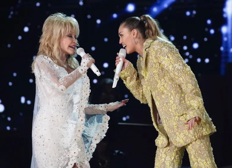 Dolly Parton y Miley Cyrus compartieron momentos como madrina-ahijada en el escenario y detrás de él, estableciendo un vínculo especial. Foto: Getty Images