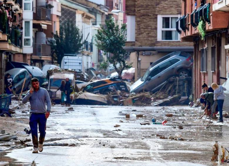 Escombros y autos dañados en medio de la desolación en las calles de Valencia. FOTO: AFP