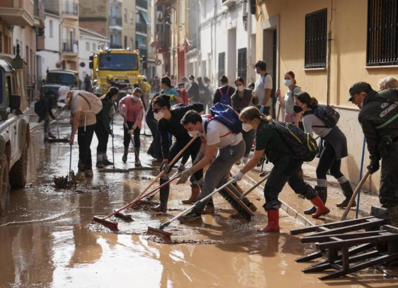 Una de tantas comunidades todavía intentando sacar el agua de sus hogares en la ciudad de Valencia, España, tras sufrir las repercusiones del fenómeno Dana. Ahora esperan la ayuda del gobierno. FOTO: AFP