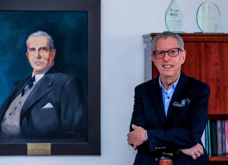 Andrés Aguirre en su oficina, en donde permanece colgada una imagen de Pablo Tobón Uribe.