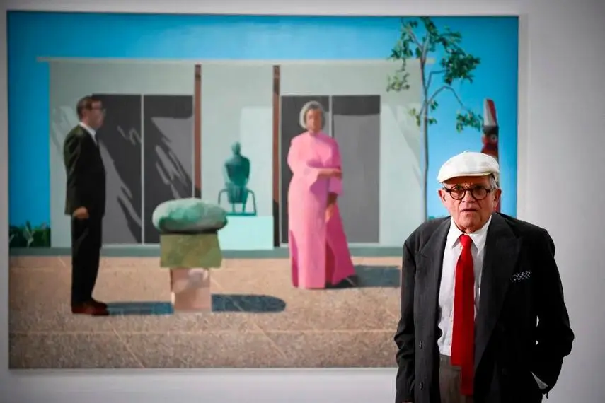 David Hockney murió a los 88 años. Aquí con una de sus pinturas <i>Fred y Marcia Weisman</i>, expuesta en París. FOTO AFP