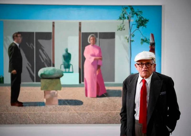 David Hockney murió a los 88 años. Aquí con una de sus pinturas Fred y Marcia Weisman, expuesta en París. FOTO AFP