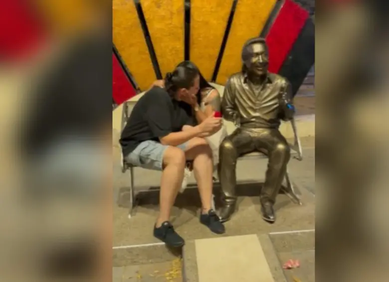 Una de las mujeres preparó la sorpresa con excusa de tomar una foto juntas al lado de la estatua. Imagen, captura de video. 