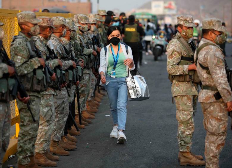 Militares y policías controlan un paradero de transporte público en Lima. FOTO: EFE