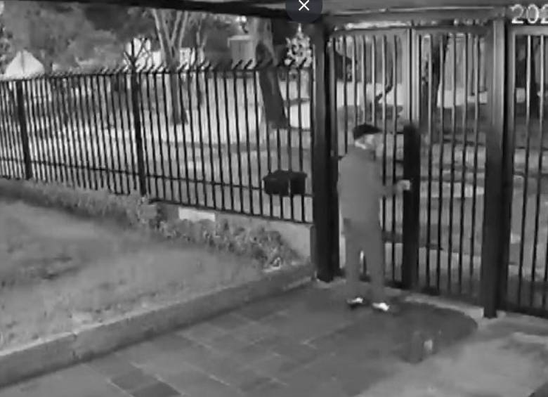 Nuchem Yisrael Eber abriendo una reja para salir a vía pública caminando. FOTO: Captura de video <i>City Tv</i>