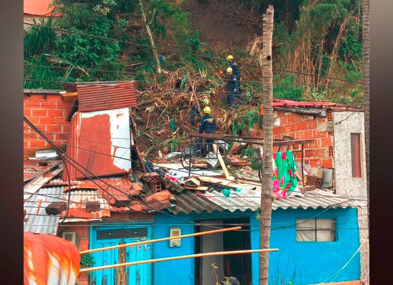 Autoridades y comunidad tratan de remover la tierra que cayó sobre la propiedad en el barrio La Unión, de Itagüí. FOTO: CORTESÍA