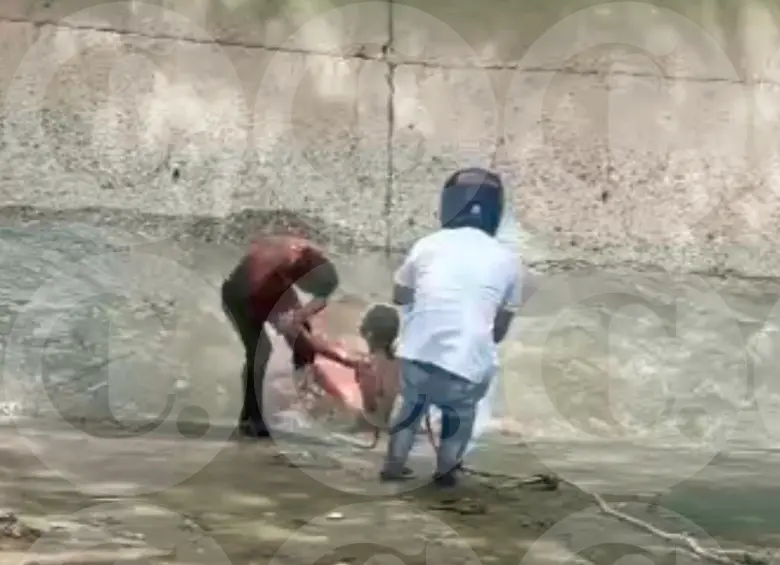 La comunidad participó en el rescate de la mujer quemada dentro de un cambuche en el Barrio Antioquia de la corriente de la quebrada La Guayabala, para luego trasladarla a la Cruz Roja. FOTO: Cortesía