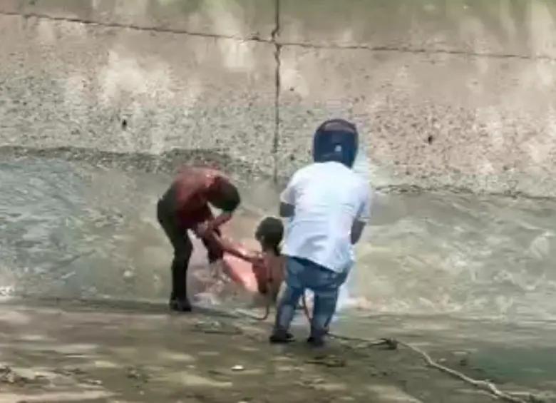 La comunidad participó en el rescate de la mujer quemada dentro de un cambuche en el Barrio Antioquia de la corriente de la quebrada La Guayabala, para luego trasladarla a la Cruz Roja. FOTO: Cortesía
