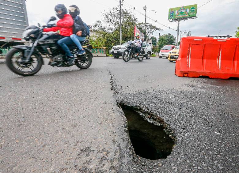 Un maletín evita que los conductores crucen sobre el hueco, para evitar que siga creciendo. FOTO: Esneyder Gutiérrez