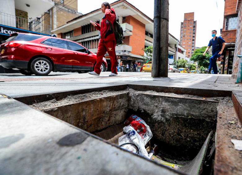 En este hueco que apareció hace cuatro meses en el Bulevár de la 70 ya se han caído varias personas. Igual situación se vive en este orificio que apareció en el centro de Medellín luego de que se robaran una tapa de alcantarilla cerca de un colegio. FOTOS: Jaime Pérez.