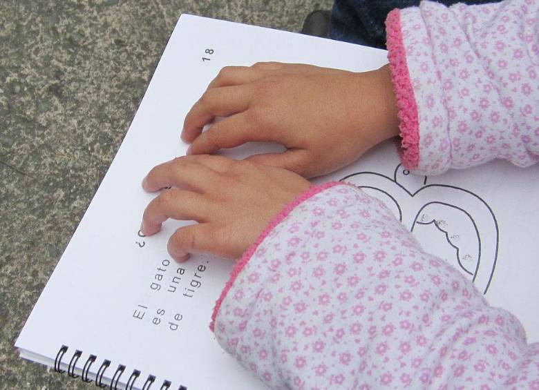 Una menor de edad leyendo un cuaderno a través de sus manos. FOTO: MINEDUACIÓN.