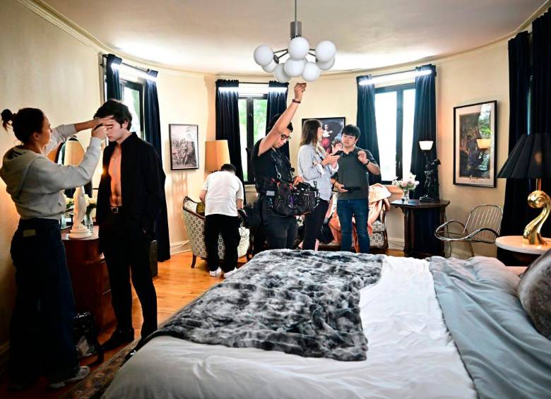 El actor ucraniano Zachary Shadrin (2º izq.) se maquilla mientras el director chino Weiyang Li (der.) comenta una escena durante el rodaje del drama vertical “Love Through All Seasons”. Foto: Afp.