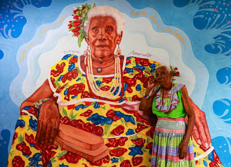 Eustiquia Amaranto Santana junto a un mural con su rostro en su casa ubicada en Turbo. FOTO: MANUEL SALDARRIAGA