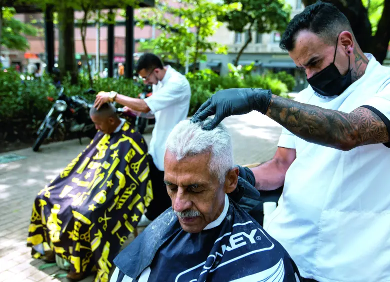 Con todos los implementos, ambos barberos motilan gratis a quien llega al Parque Bolívar. FOTO Julio Herrera.