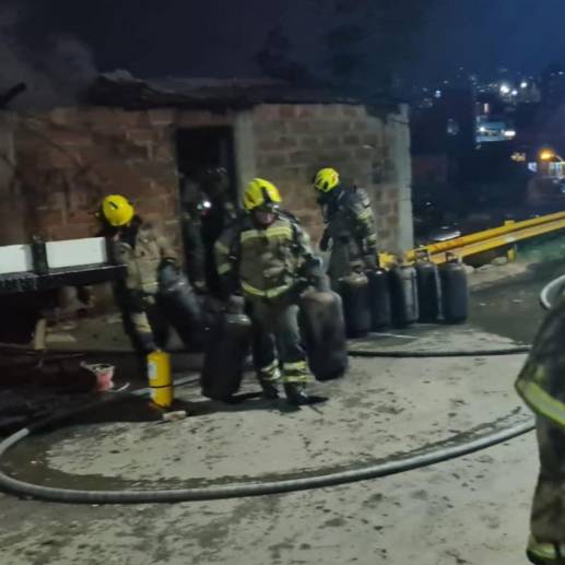 Bomberos evacuando parte de las pipetas que estaban en el local incendiado. FOTO: Cortesía.