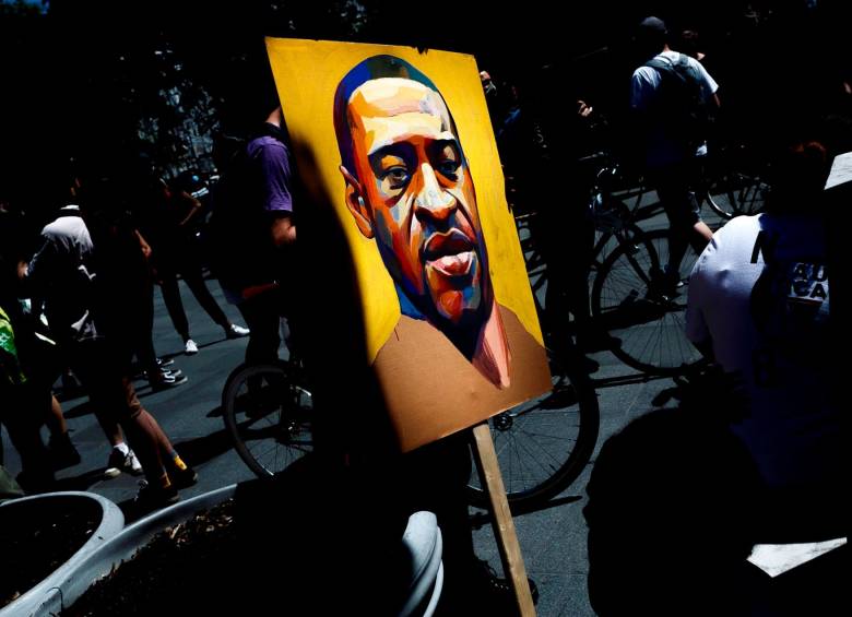 Un manifestante sostiene una imagen con el rostro de George Floyd, el afroamericano asesinado por un policía blanco el pasado mayo, durante una nueva protesta de “Black Lives Matter” en Brooklyn, Nueva York (Estados Unidos). FOTO EFE 