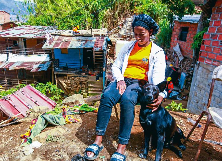 Marcelina Valencia está al lado de su perra, sentada en una silla, viendo cómo funcionarios de la Alcaldía tumban su vivienda y la de su hermano. FOTO: JULIO CÉSAR HERRERA