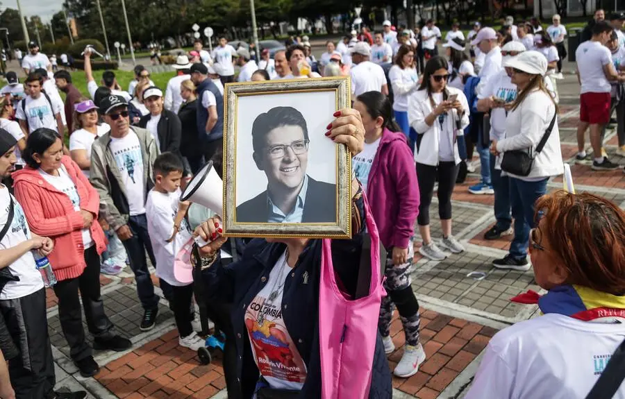 Una mujer sosteniendo un cuadro con el rostro de Miguel Uribe en la “Carrera por la Vida”, en respaldo a la salud del senador. FOTO: COLPRENSA