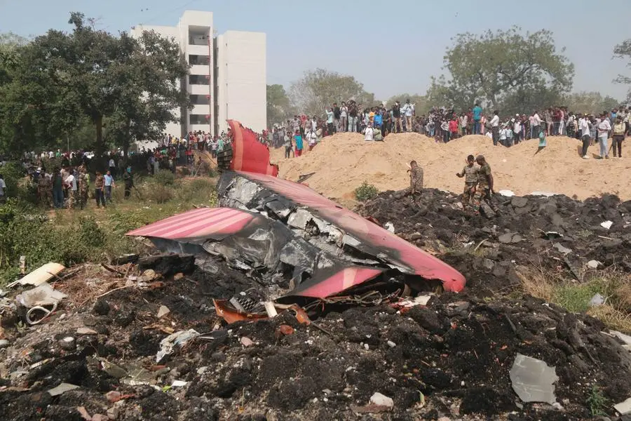 Personas observan los restos de un avión de Air India que se estrelló, en Ahmedabad, en el estado de Gujarat, India, el 12 de junio de 2025. El vuelo de Air India con destino a Londres, que llevaba 242 personas a bordo, incluidos dos pilotos y 10 miembros de la tripulación. Imagen tomada de Agencia Xinhua.